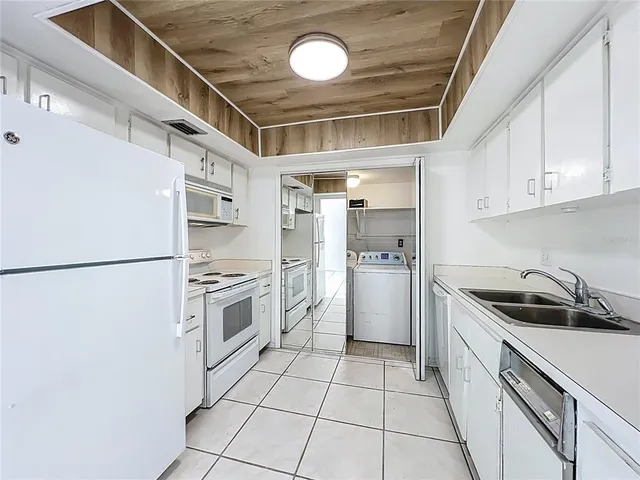 a kitchen with a refrigerator a stove a sink and cabinets