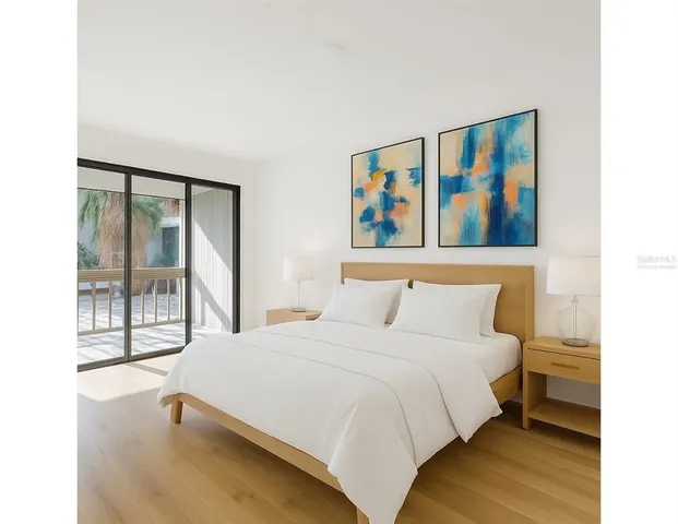 a view of an empty room with wooden floor and a bathroom