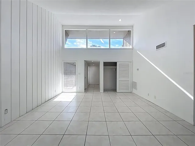 a view of an empty room with cabinet and a window