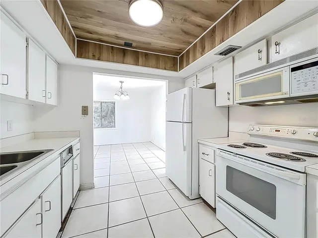 a kitchen with white cabinets and white appliances