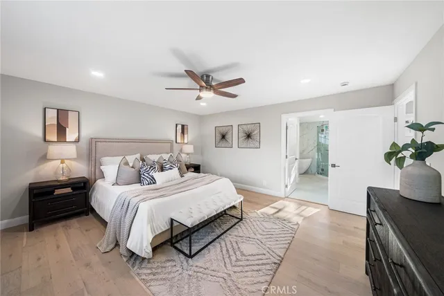 a bedroom with a large bed chandelier and a window