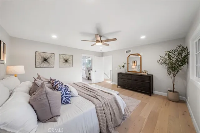 a bedroom with a bed large mirror and a potted plant