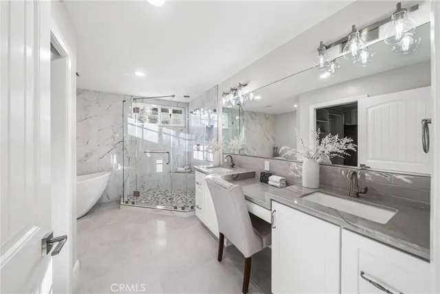 a bathroom with a granite countertop sink a large mirror and shower