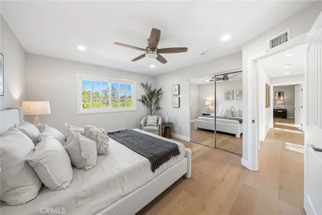 a spacious bedroom with a bed and ceiling fan