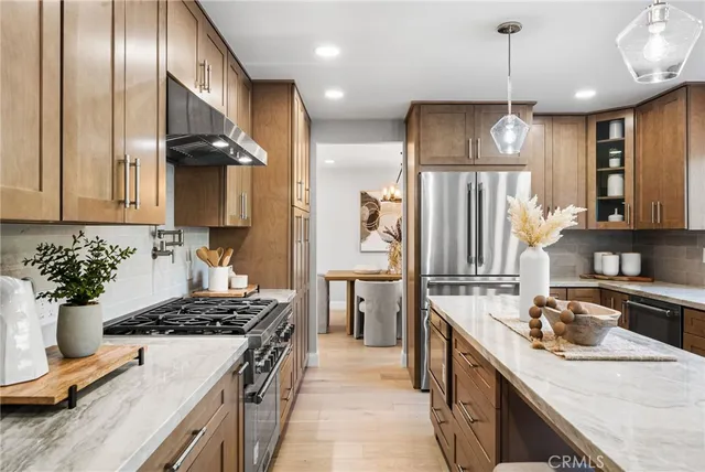 a kitchen with stainless steel appliances granite countertop a sink a stove and a refrigerator