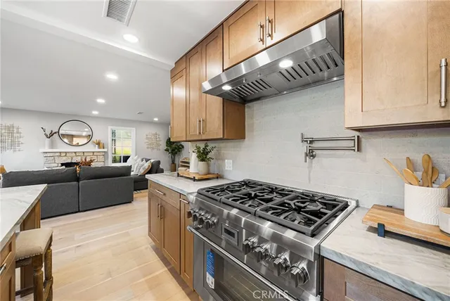 a kitchen with stainless steel appliances granite countertop a stove a sink and a microwave
