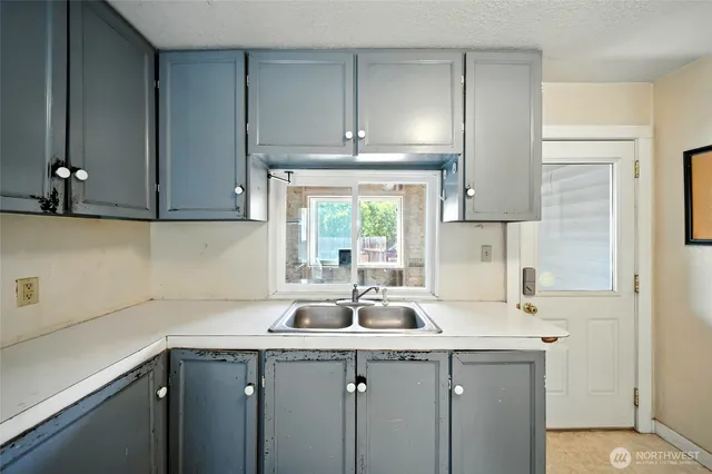 a kitchen with a sink cabinets and window