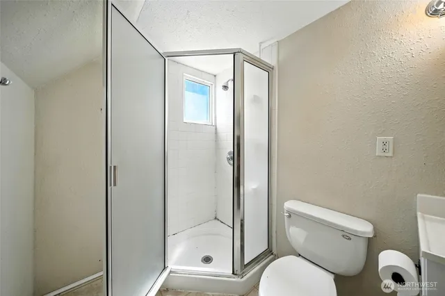 a bathroom with a toilet and a shower