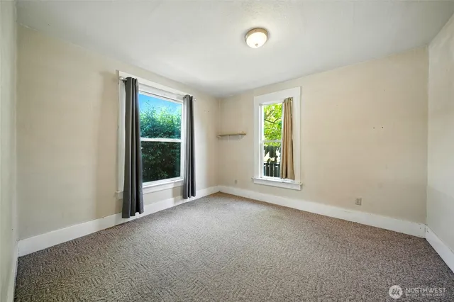 an empty room with windows and closet