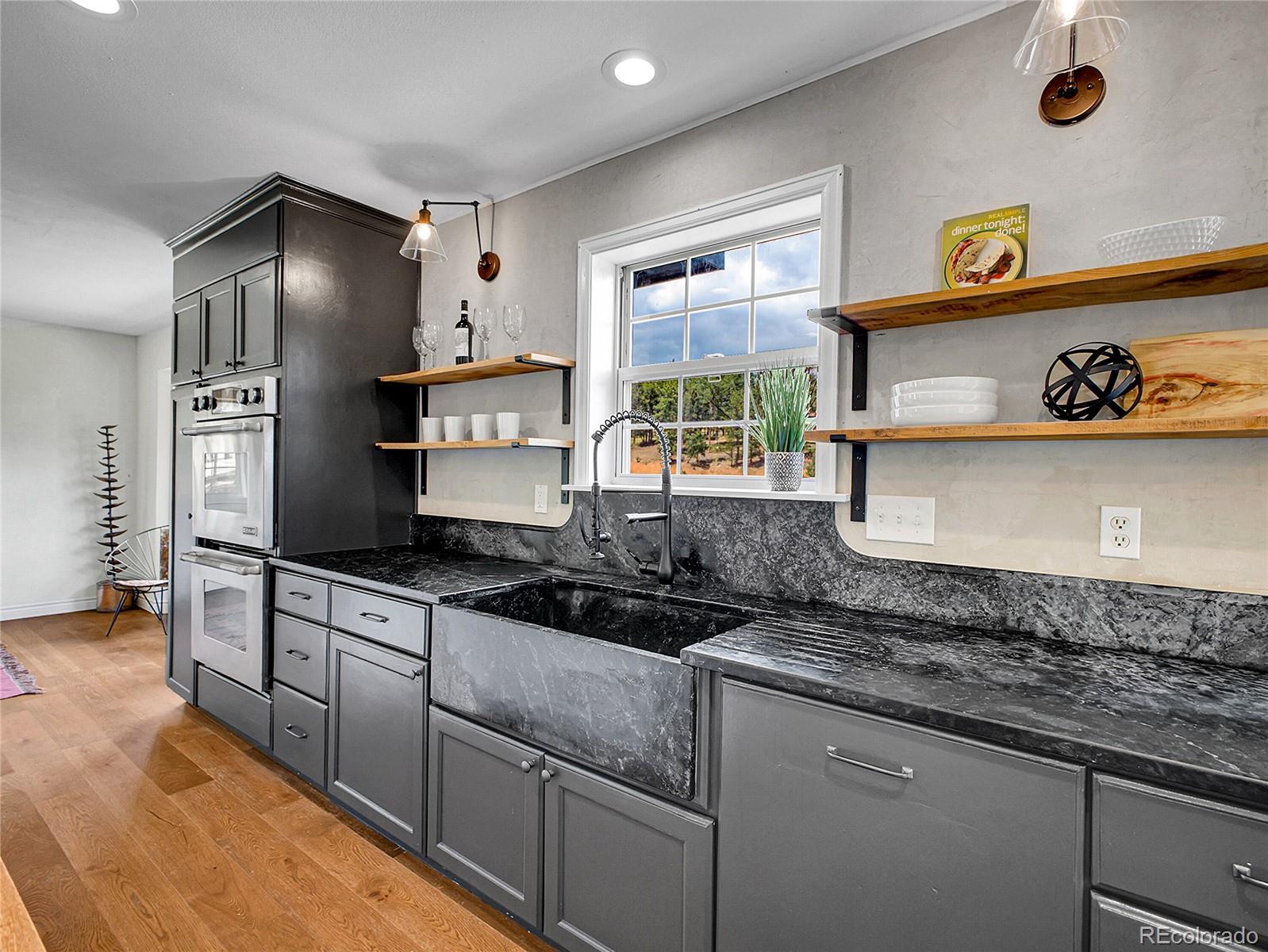 2635 Nova Road Pine, CO 80470 - Photo 11 of 45 a kitchen with granite countertop stainless steel appliances a stove refrigerator and cabinets