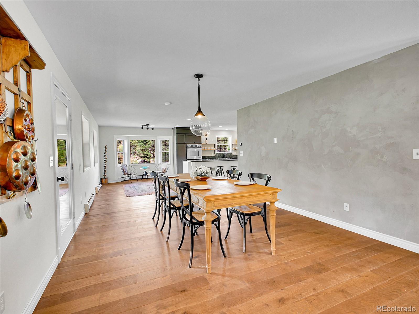 2635 Nova Road Pine, CO 80470 - Photo 17 of 45 a dining room with furniture a chandelier and wooden floor