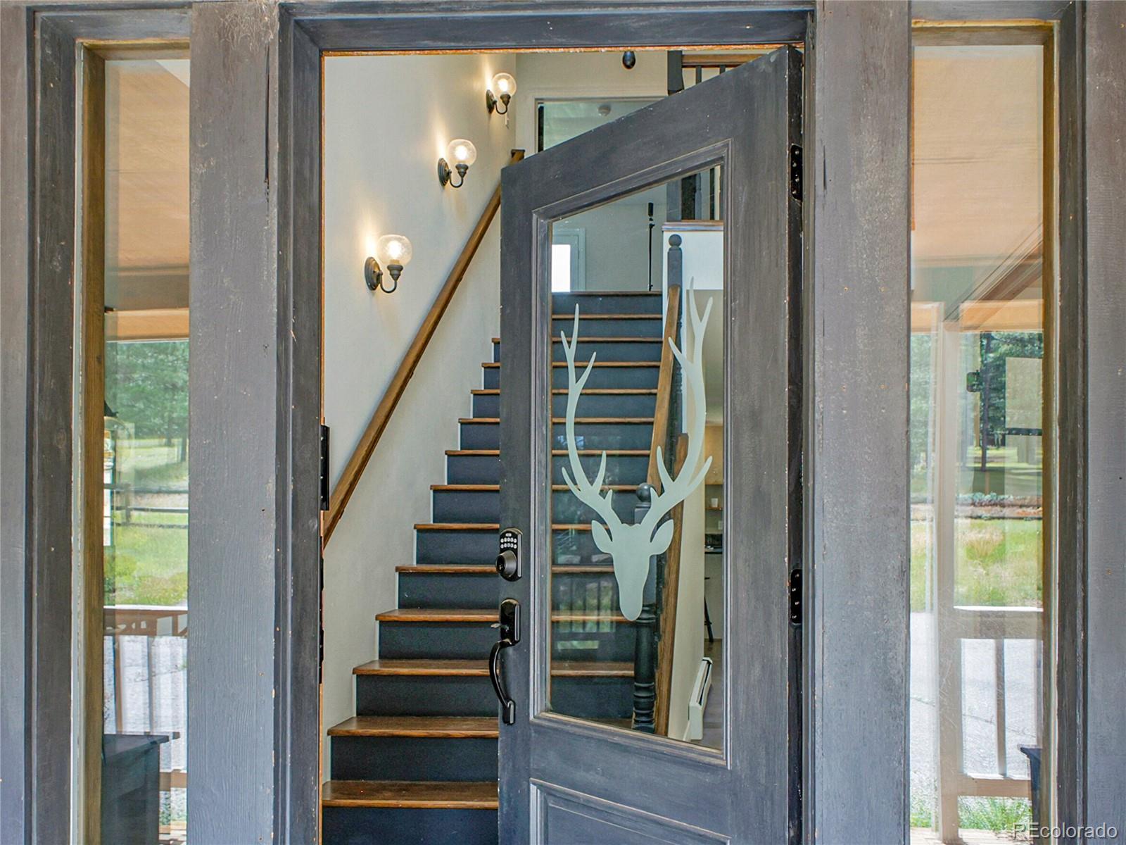 2635 Nova Road Pine, CO 80470 - Photo 3 of 45 a view of entryway with wooden floor and windows