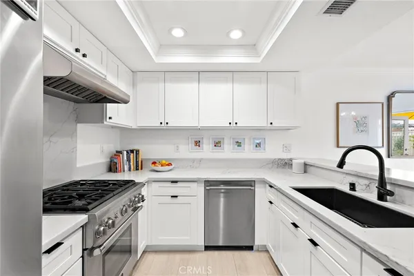 a kitchen with stainless steel appliances a sink a stove and cabinets