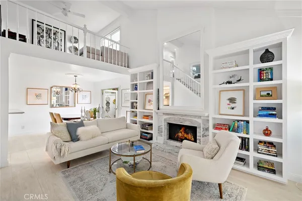 a living room with fireplace furniture a rug and a bookshelf
