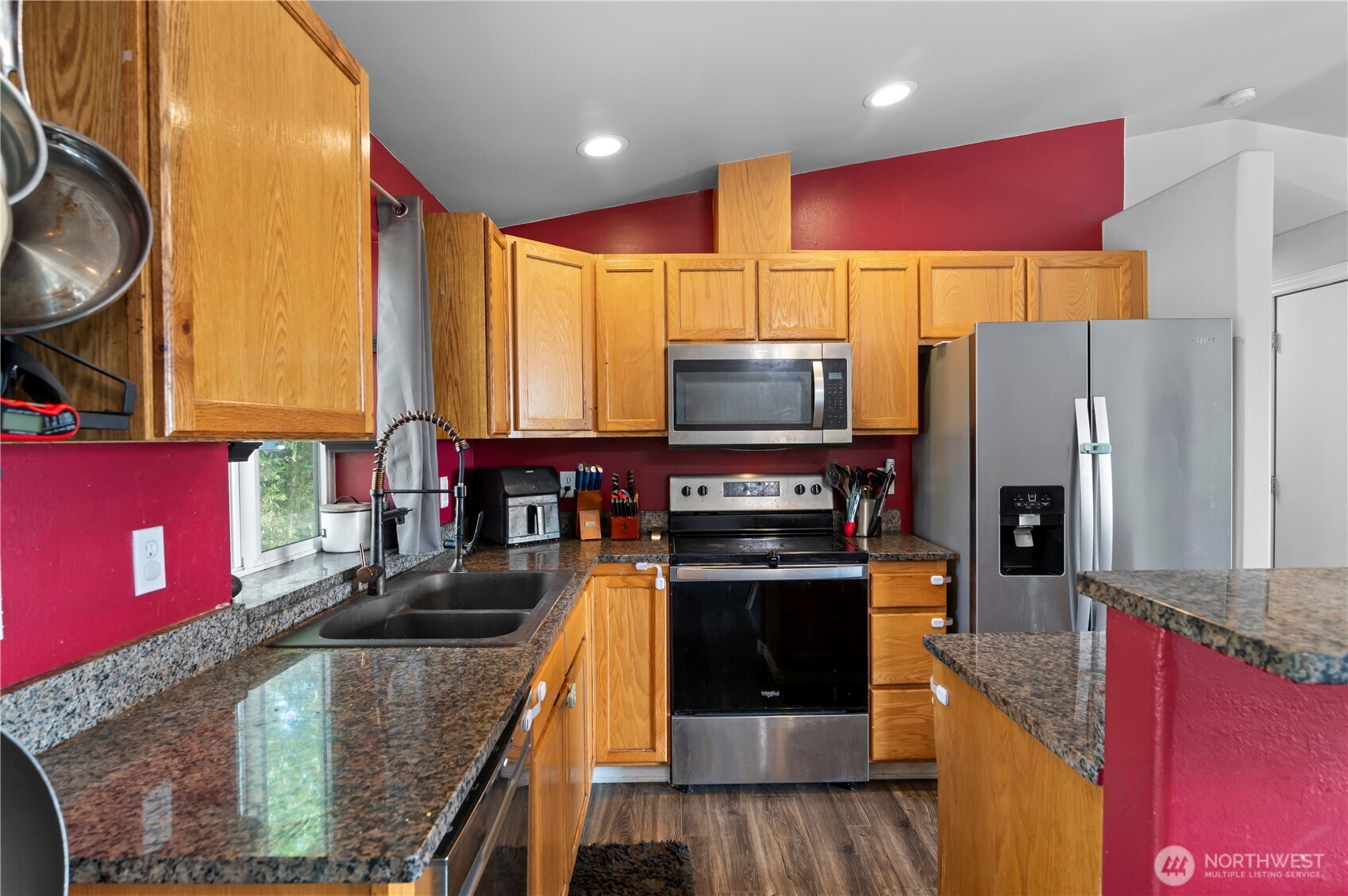 7805 260th Street Northwest Stanwood, WA 98292 - Photo 11 of 25 a kitchen with stainless steel appliances granite countertop a stove a refrigerator and a microwave