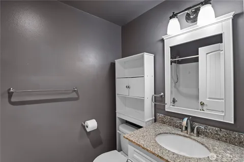 a bathroom with a granite countertop sink toilet and shower