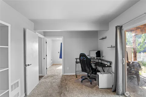 a view of a workspace with furniture and a window