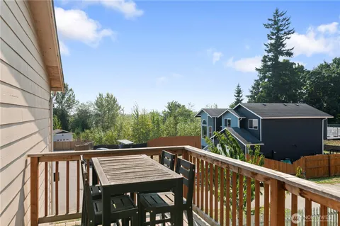 a view of a roof deck with table and chairs with wooden fence and floor