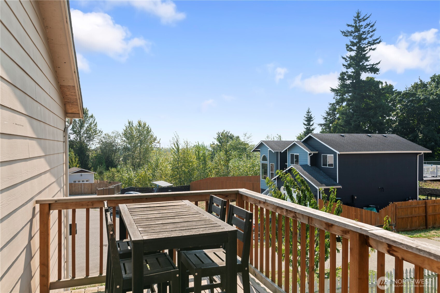 7805 260th Street Northwest Stanwood, WA 98292 - Photo 4 of 25 a view of a roof deck with table and chairs with wooden fence and floor