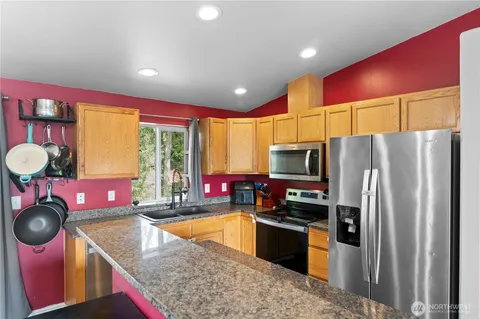 a kitchen with stainless steel appliances granite countertop a sink stove and refrigerator