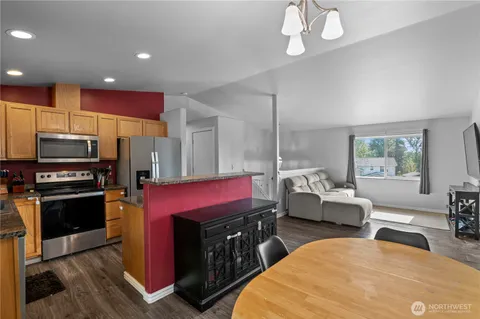 a kitchen with stainless steel appliances kitchen island granite countertop a stove a refrigerator and a sink