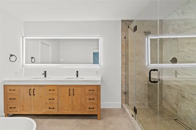 a bathroom with a granite countertop sink a toilet a mirror and shower