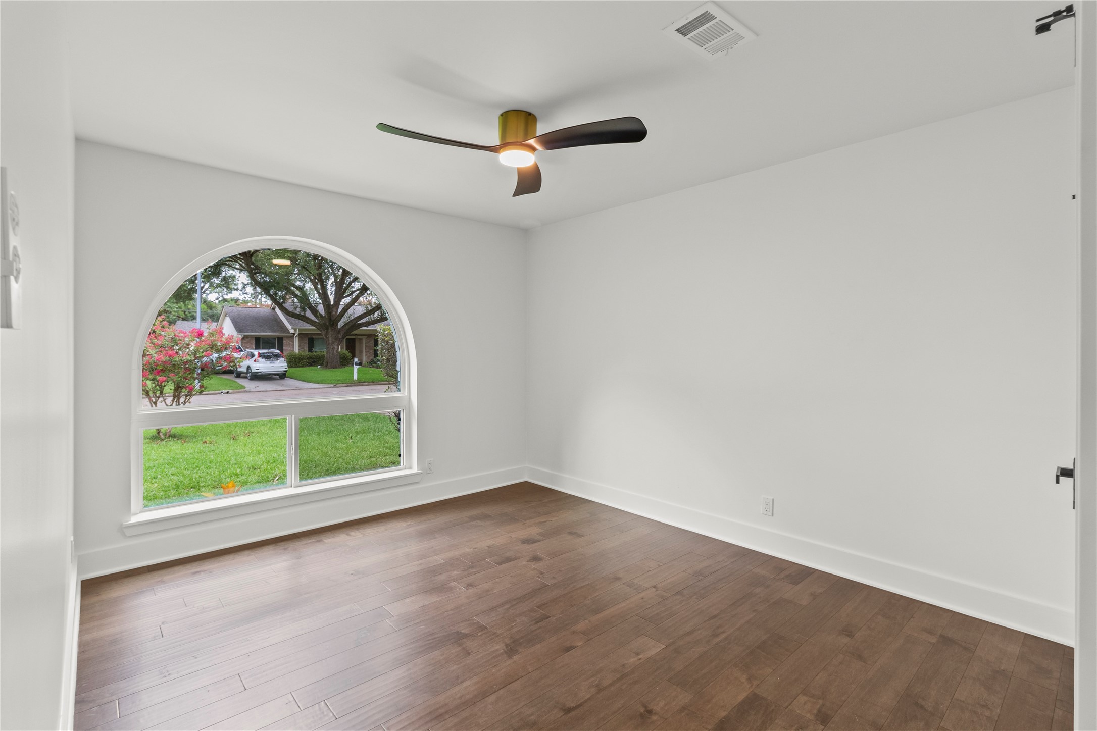 2823 Stetson Lane Houston, TX 77043 - Photo 15 of 19 an empty room with a large window and wooden floor