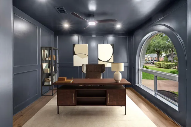 a view of empty room with wooden floor and fan