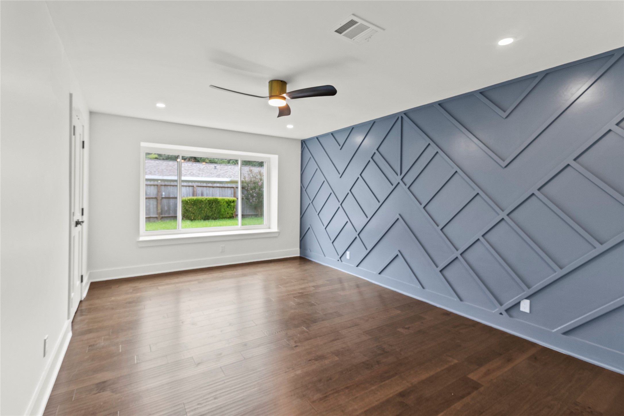 2823 Stetson Lane Houston, TX 77043 - Photo 7 of 19 a view of an empty room with a window and wooden floor