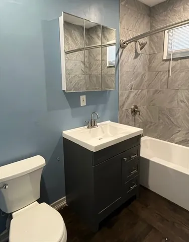 a bathroom with a sink and mirror with toilet