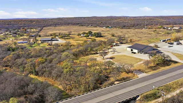 an aerial view of residential houses with outdoor space and trees