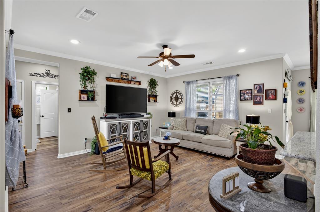 701 West Lamberth Road Sherman, TX 75092 - Photo 9 of 37 Open-concept living space featuring wood-finish flooring, a ceiling fan with integrated lighting, recessed lighting fixtures, crown molding, and a white media console with glass panel doors