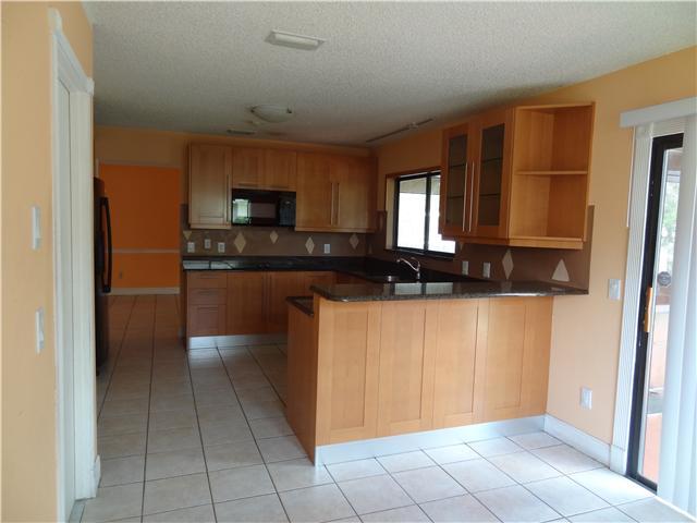1601 Southwest Fortune Road Port St. Lucie, FL 34953 - Photo 8 of 23 a kitchen with a refrigerator and a stove top oven