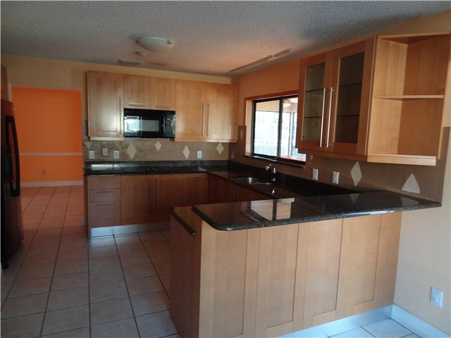 1601 Southwest Fortune Road Port St. Lucie, FL 34953 - Photo 10 of 23 a kitchen with a sink and a refrigerator