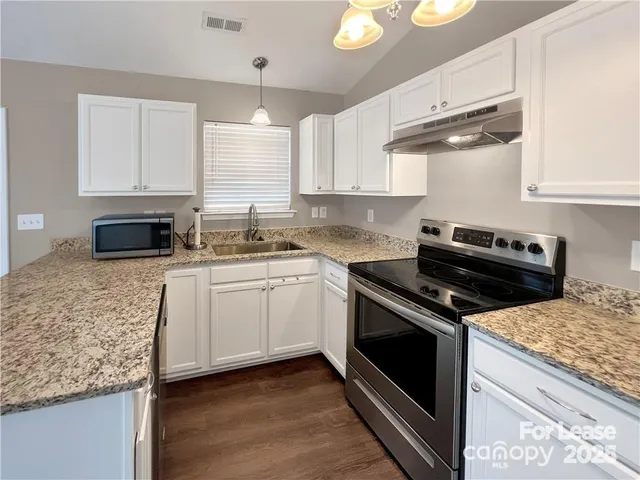 a kitchen with cabinets appliances and a sink
