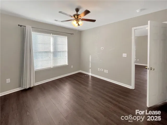 an empty room with wooden floor and window