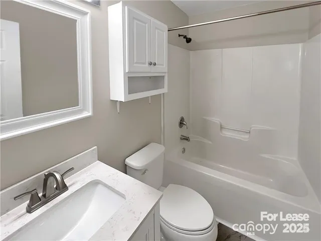 a white toilet sitting next to a bath tub