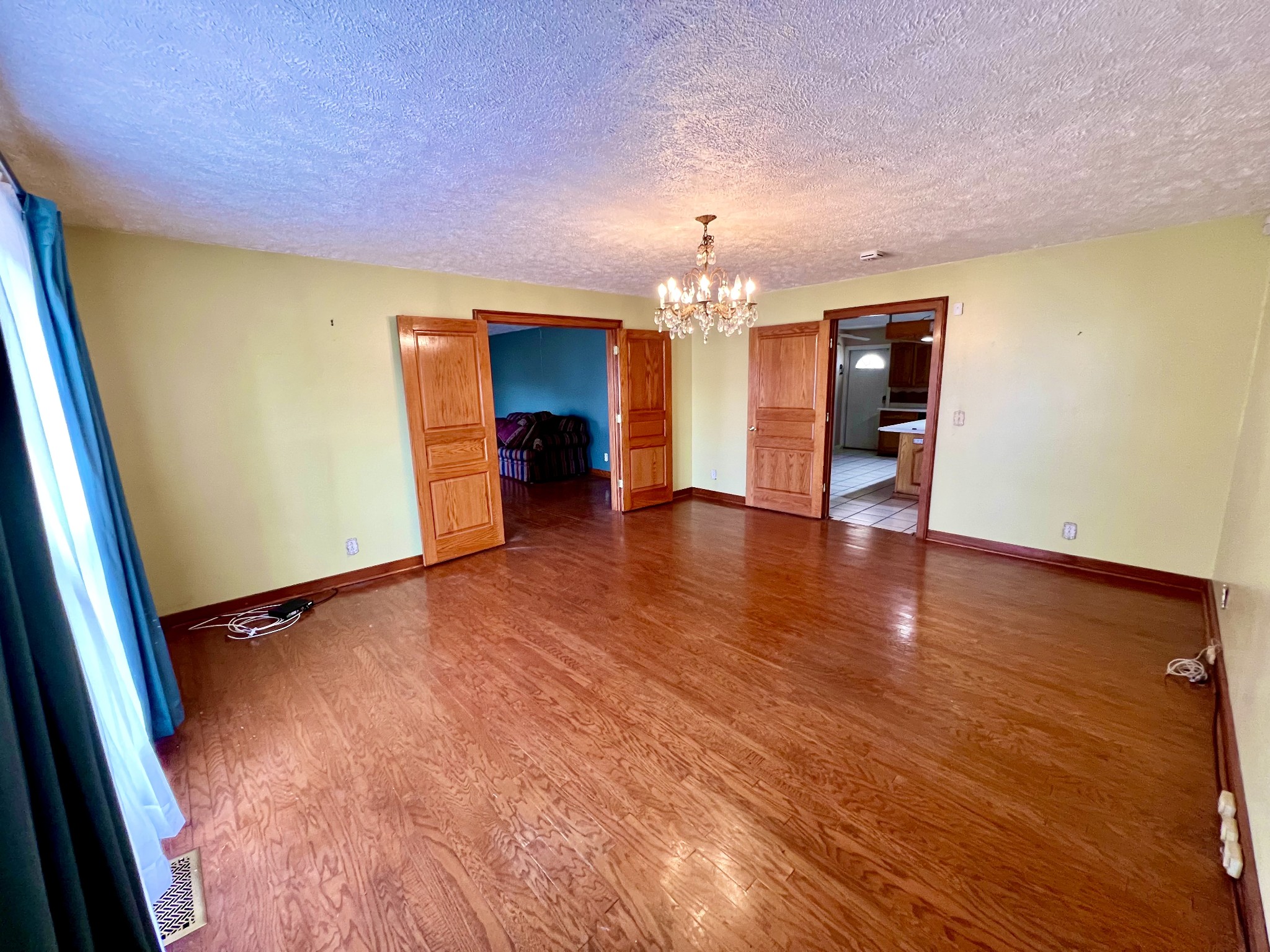 1100 Buffalo Road Lawrenceburg, TN 38464 - Photo 18 of 56 an empty room with wooden floor and chandelier