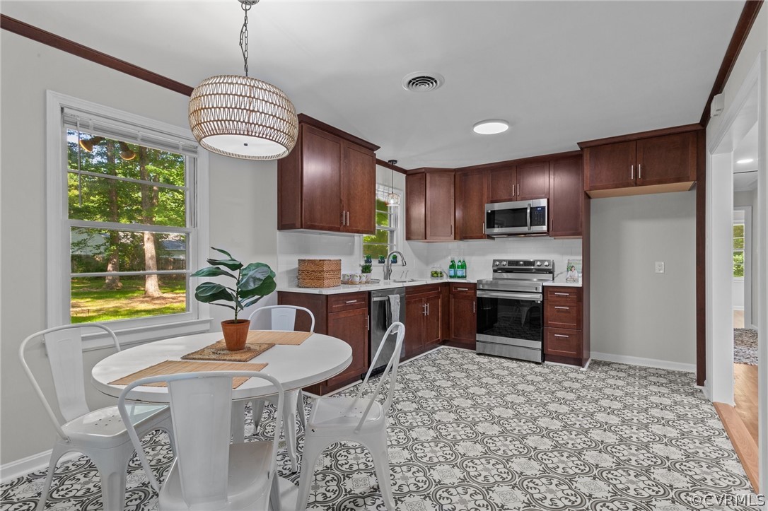 3910 Turner Road Chesterfield, VA 23832 - Photo 13 of 37 a kitchen with stainless steel appliances granite countertop a stove a refrigerator a sink dishwasher a dining table and chairs with wooden floor