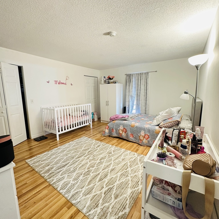 8 Shadowbrook Lane, Unit 38 Milford, MA 01757 - Photo 12 of 16 a bedroom with a bed and wooden floor