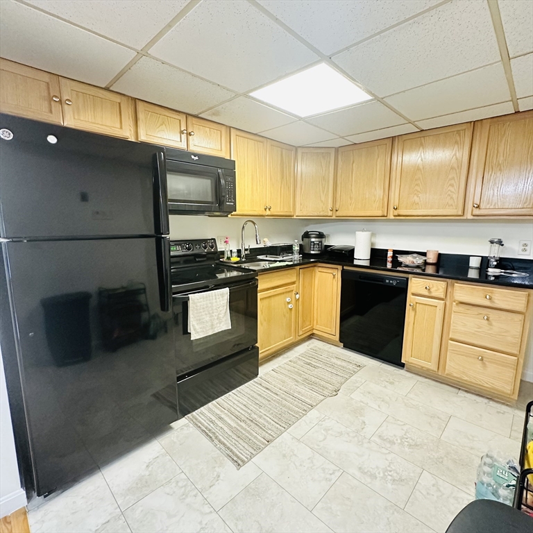 8 Shadowbrook Lane, Unit 38 Milford, MA 01757 - Photo 6 of 16 a kitchen with stainless steel appliances granite countertop a sink counter space cabinets and a large window