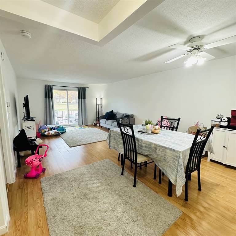8 Shadowbrook Lane, Unit 38 Milford, MA 01757 - Photo 9 of 16 a living room with furniture and a chandelier