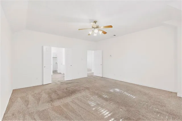 a view of a room with wooden floor and a ceiling fan