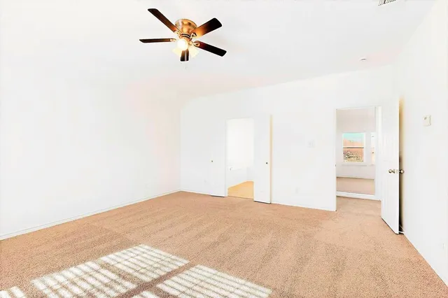 a view of a big room with wooden floor and a ceiling fan