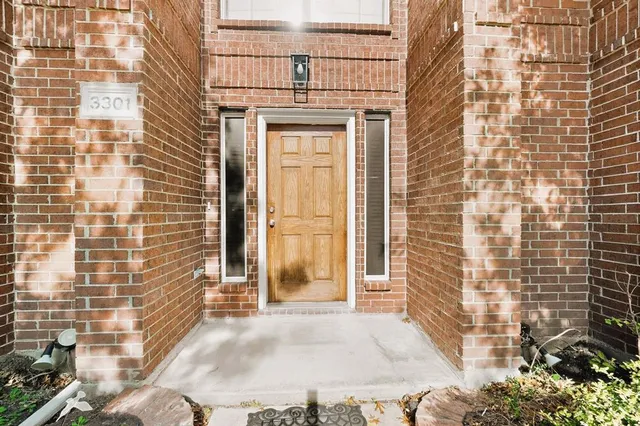 a view of an empty room with wooden floor and a fireplace