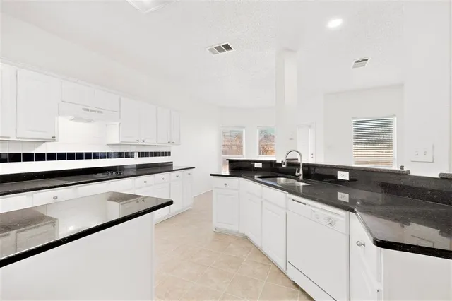a large kitchen with stainless steel appliances granite countertop a sink and a stove