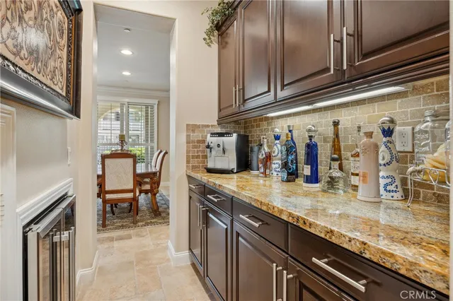 a kitchen with stainless steel appliances granite countertop table chairs stove and refrigerator