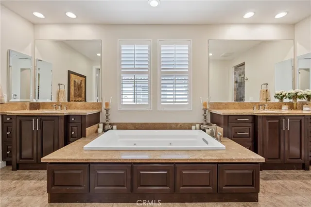 a bathroom with a granite countertop sink and a large mirror