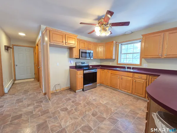 a kitchen with stainless steel appliances granite countertop a refrigerator a sink a stove and island
