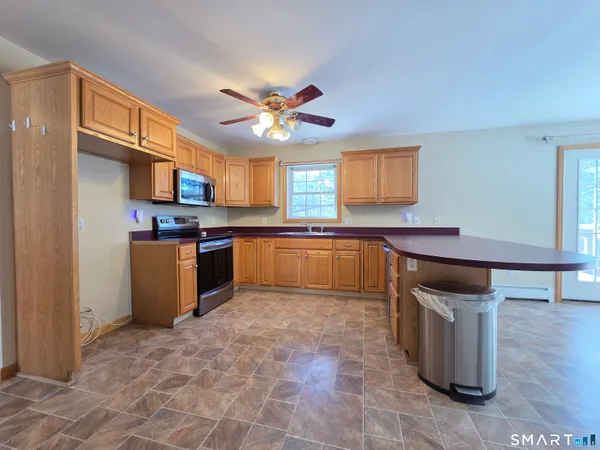 a kitchen with stainless steel appliances granite countertop a sink cabinets and window